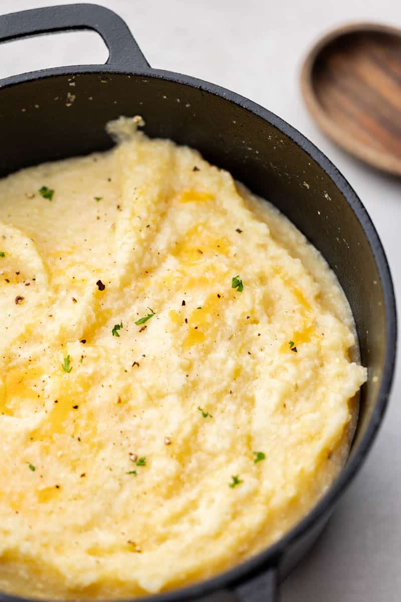 Overhead view of cheese grits in a cast iron pan.