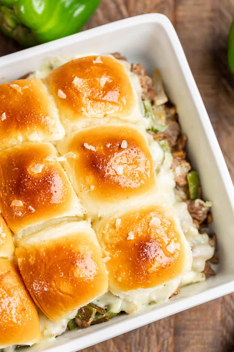 Overhead view of cheesesteak sliders in a baking dish.