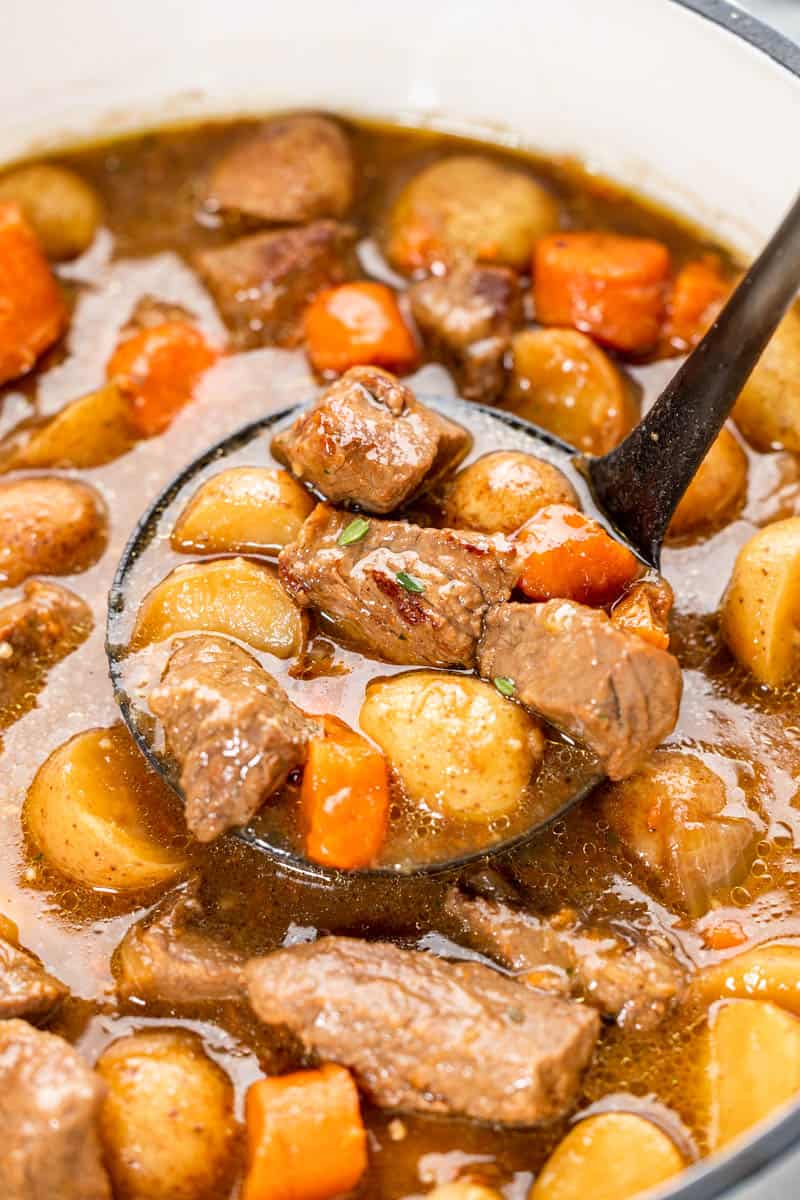 A ladle filled with Irish stew.