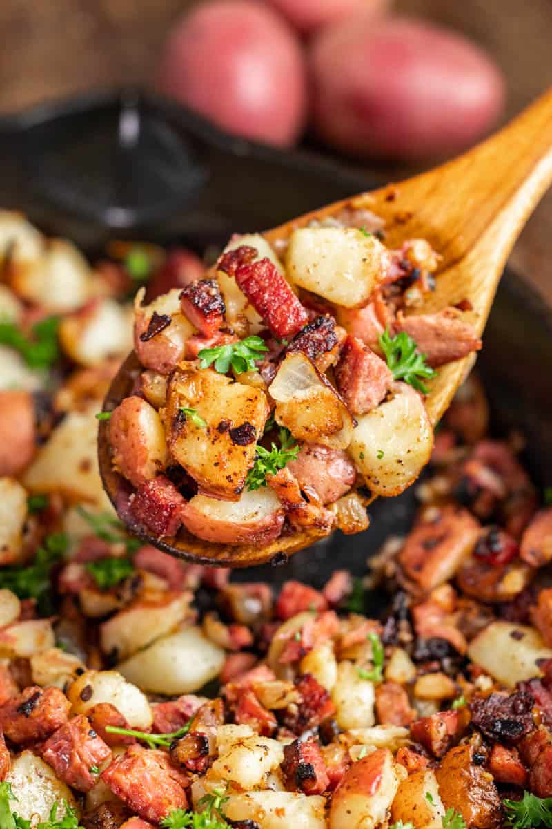 A wooden spoon with corned beef hash.