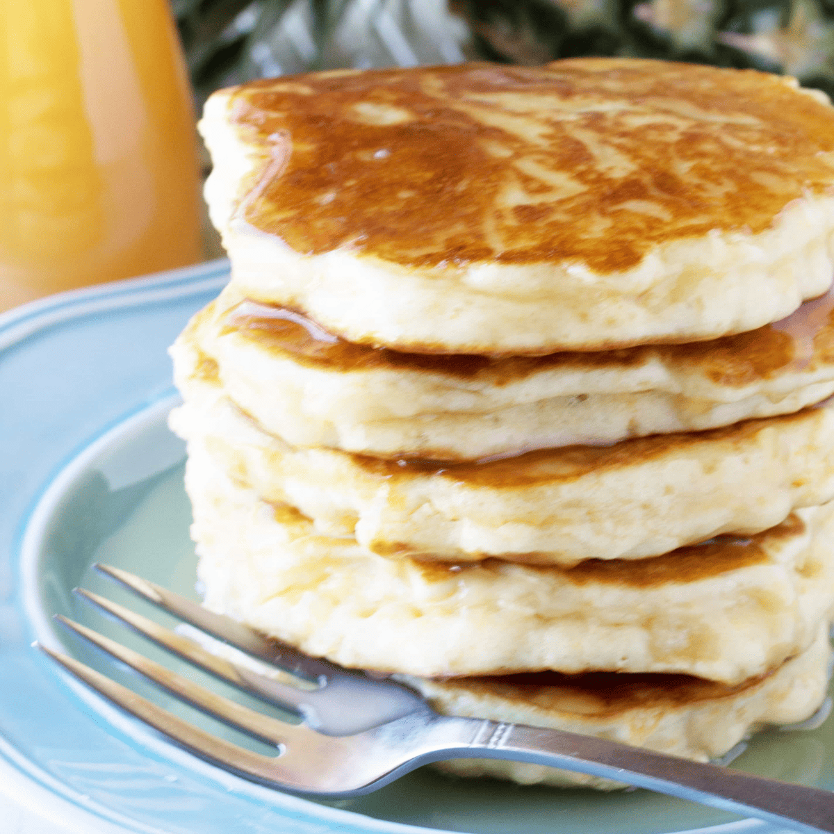Stack of pineapple pancakes with coconut syrup.