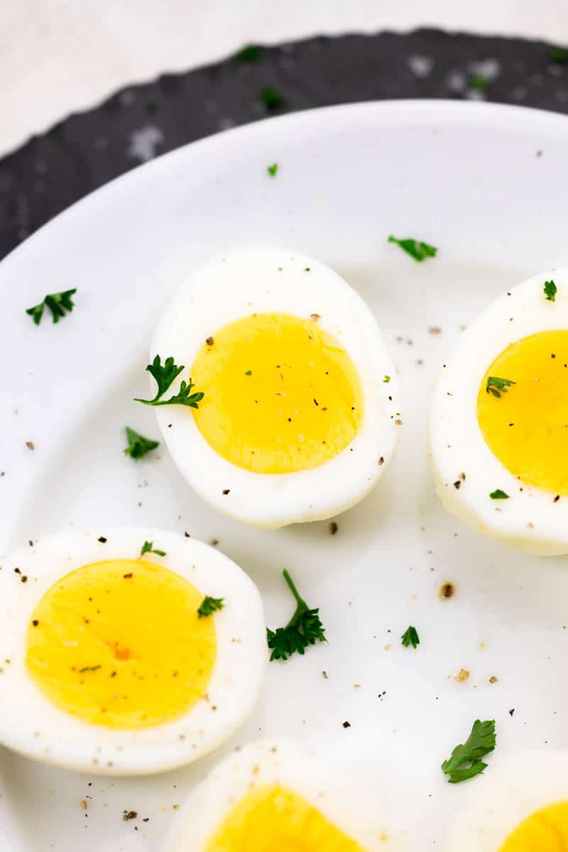 Overhead view of a plate of hard-boiled eggs cut in half.