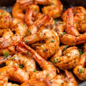 Cajun shrimp on a black plate.