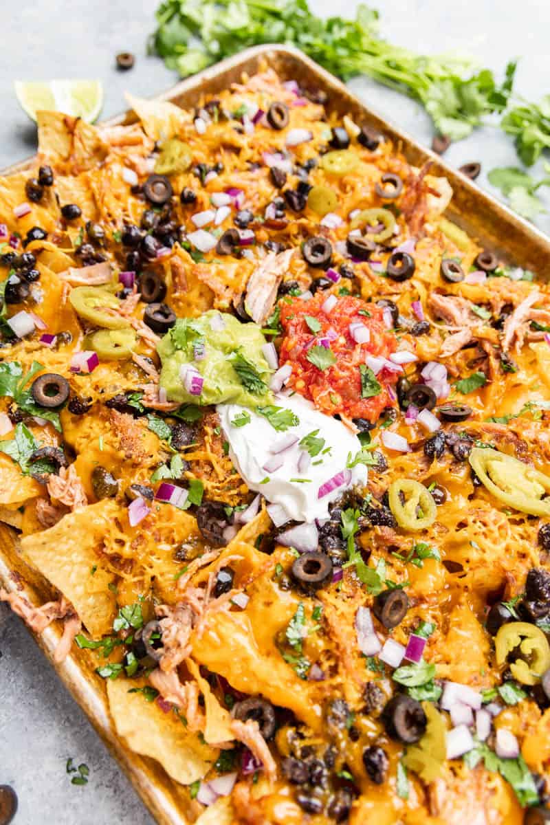 Pulled pork nachos on a baking sheet.