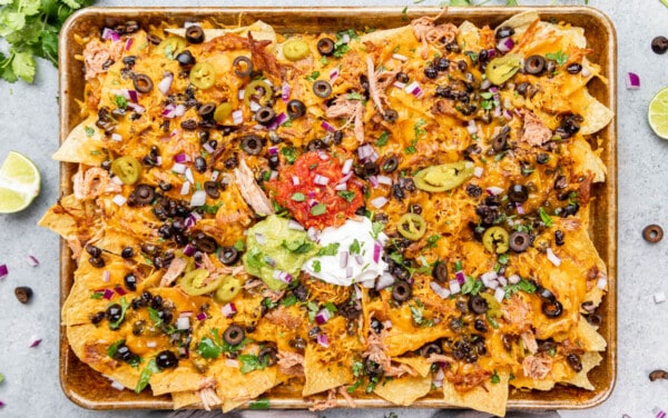 Overhead view of a baking sheet filled with pulled pork nachos.