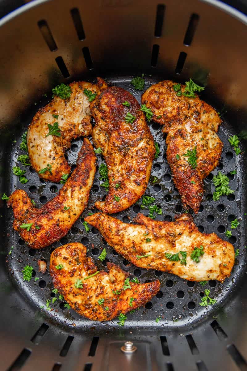 Overhead view of naked chicken tenders in an air fryer.