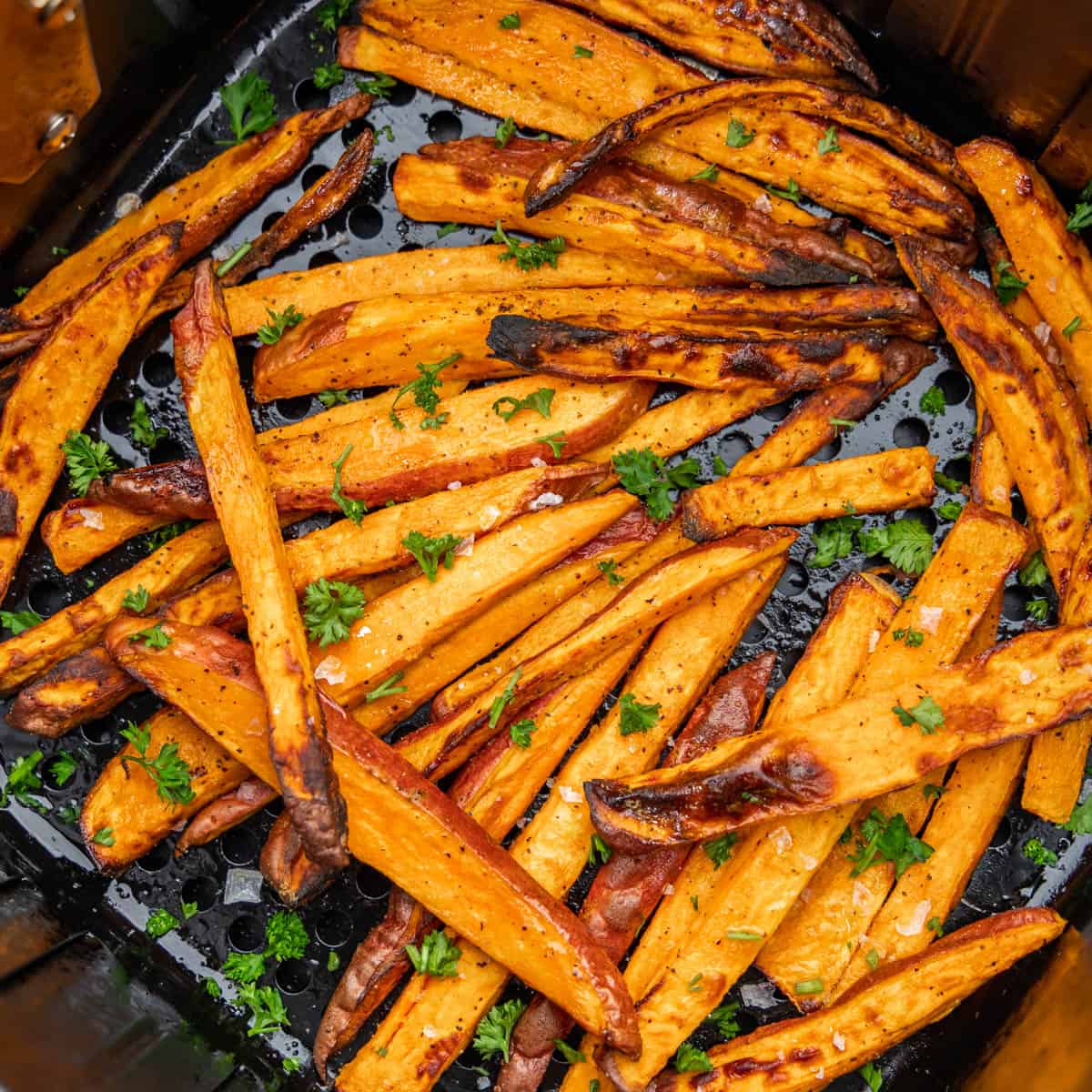 An overhead view of sweet potato fries in an air fryer basket.