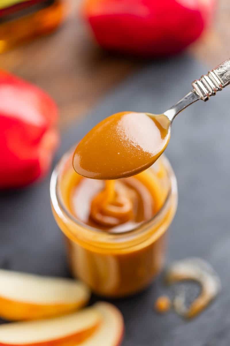 Overhead view of a spoon filled with apple bourbon caramel sauce.