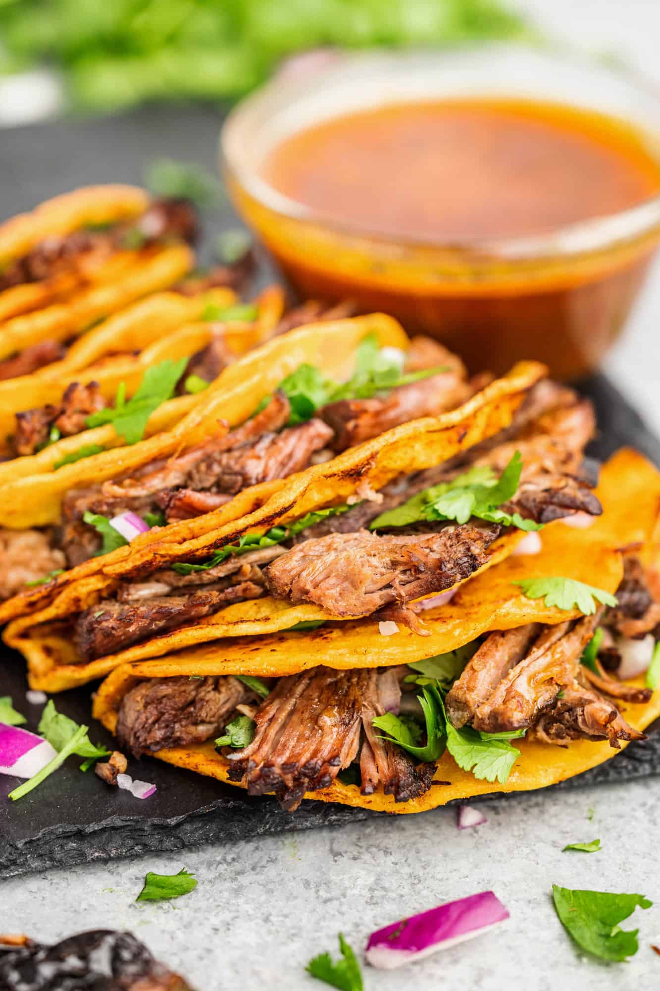 Birria tacos on a serving platter.