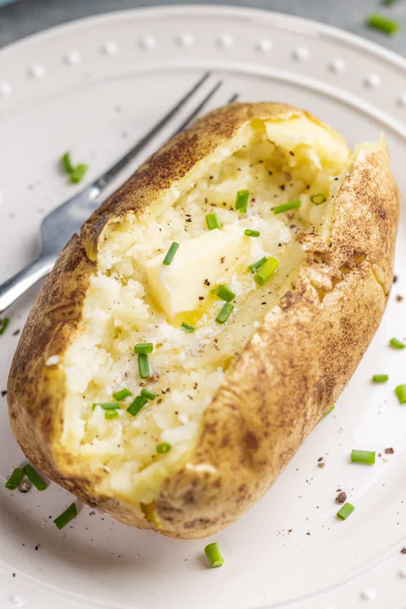 A baked potato cut open with butter inside. 
