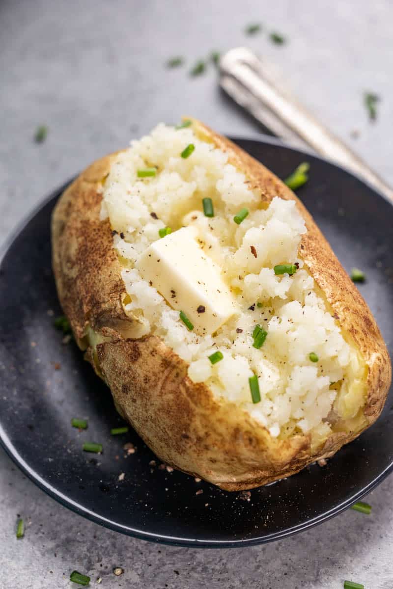 Overhead view of a baked potato on a dinner plate.