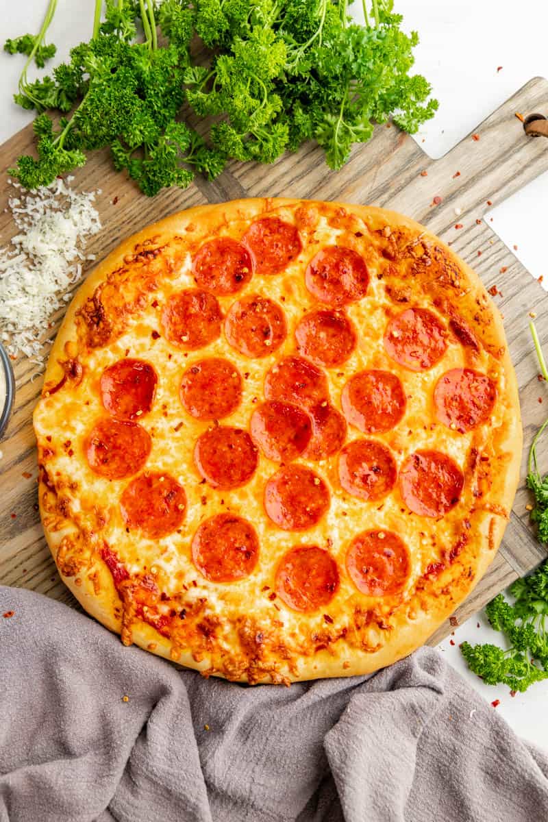 Overhead view of an uncut, homemade pepperoni pizza.