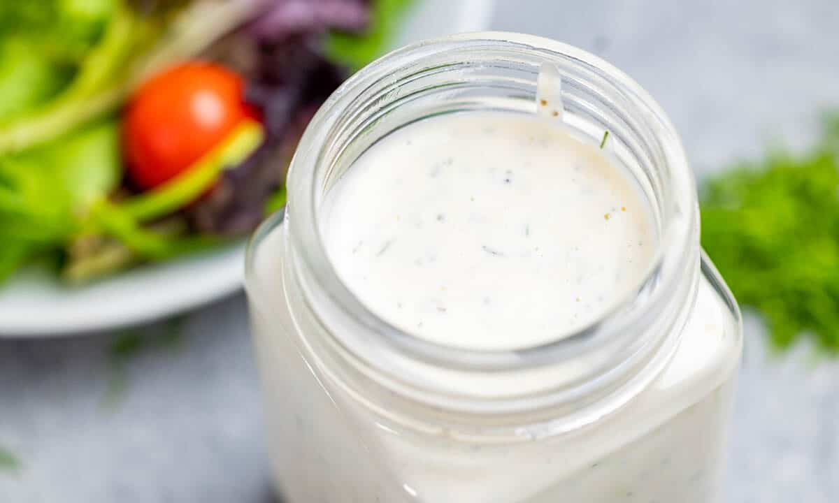 Close up view of ranch dressing in a glass jar.