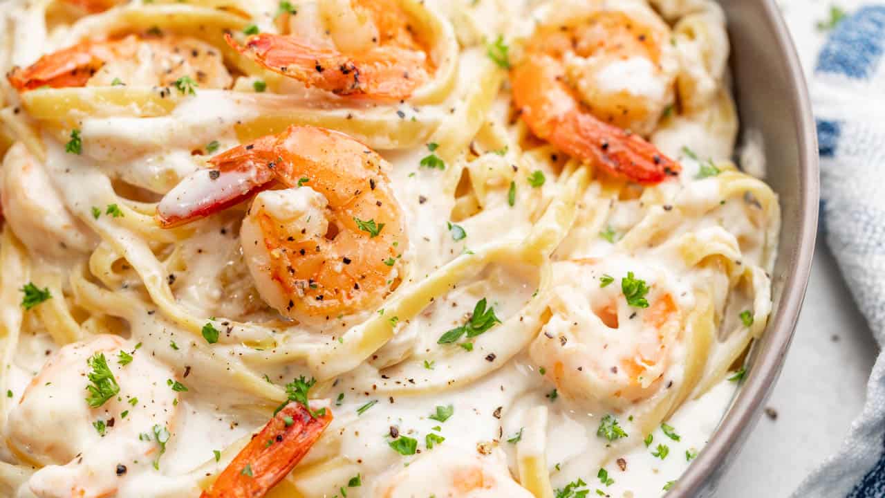 Close up overhead view of shrimp Alfredo in a bowl.
