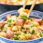 Chopsticks holding a small amount of spam fried rice.