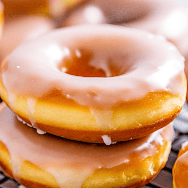 Air fryer glazed donuts sitting on a wire cooling rack.
