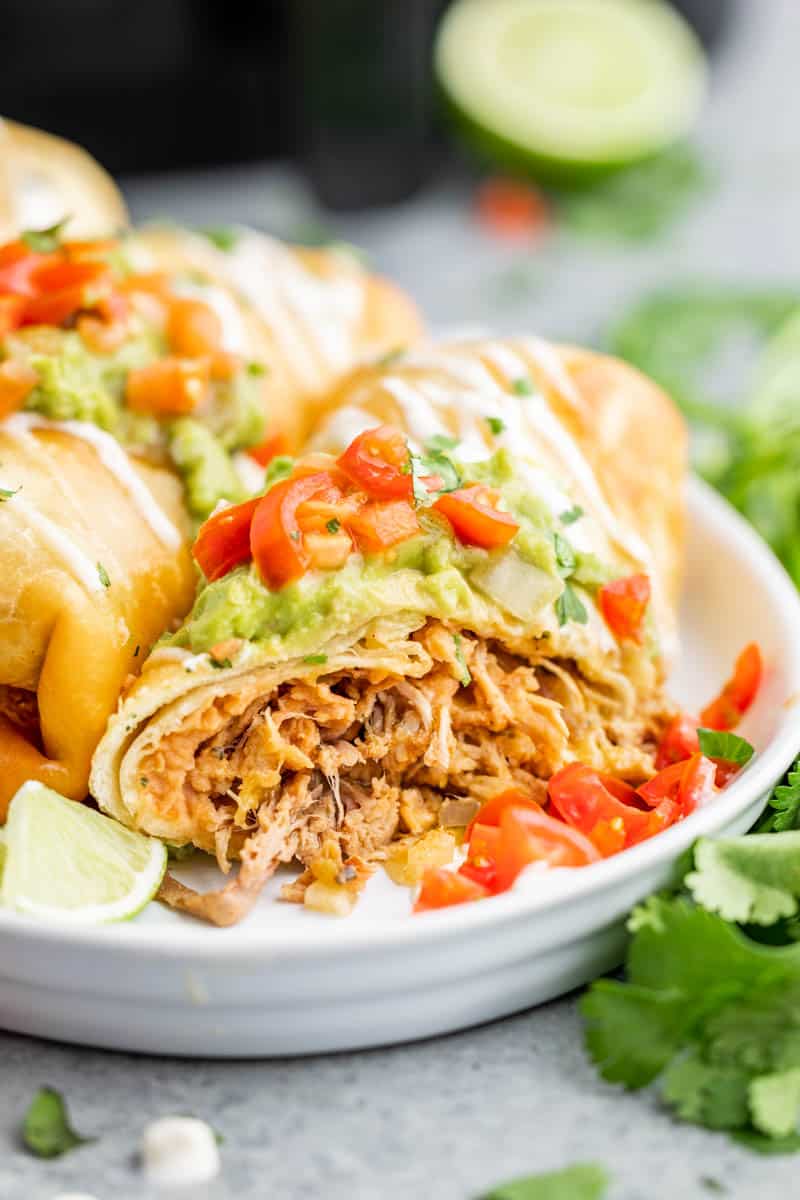 An air fried chimichanga on a white plate.