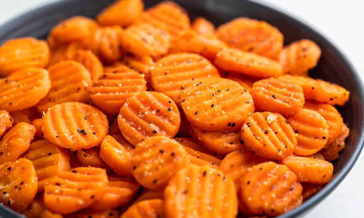 Cooked, sliced carrots in a serving bowl.