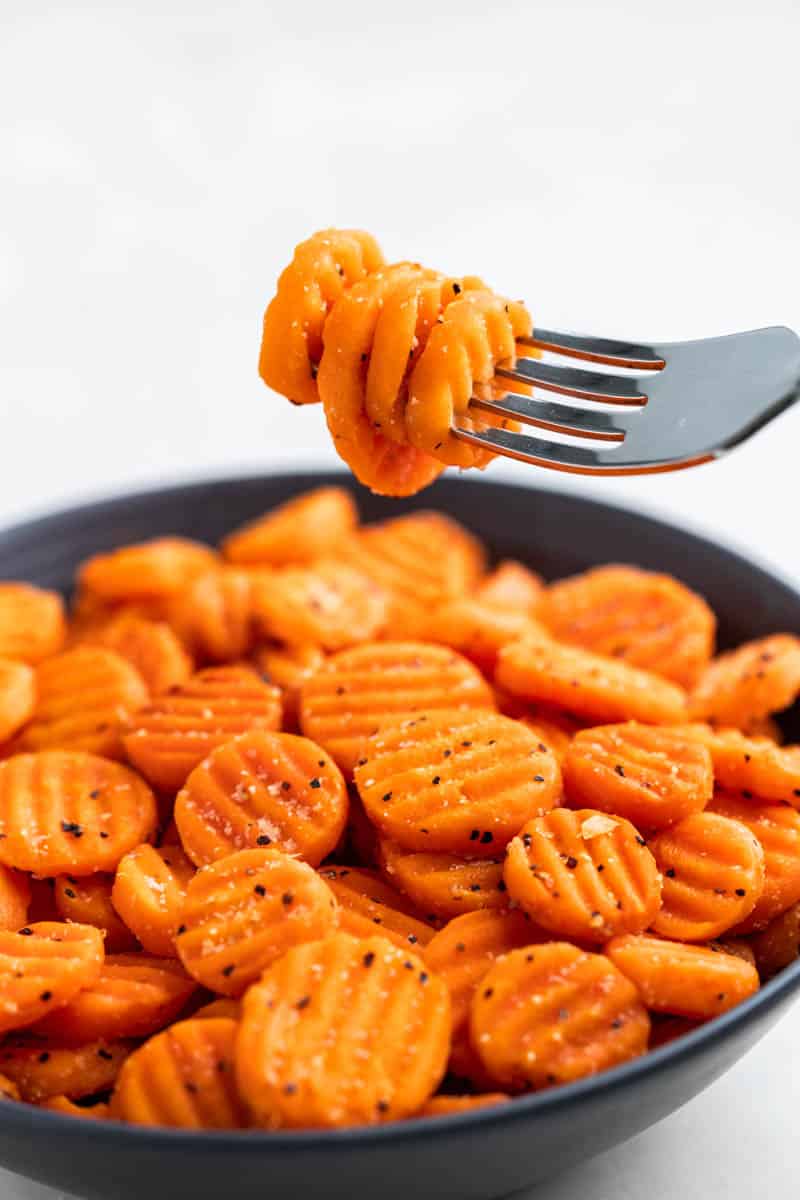A fork filled with sliced carrots.