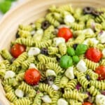 Close up view of a bowl filled with pesto pasta salad.