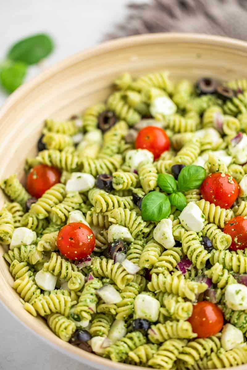 Close up view of a bowl filled with pesto pasta salad.