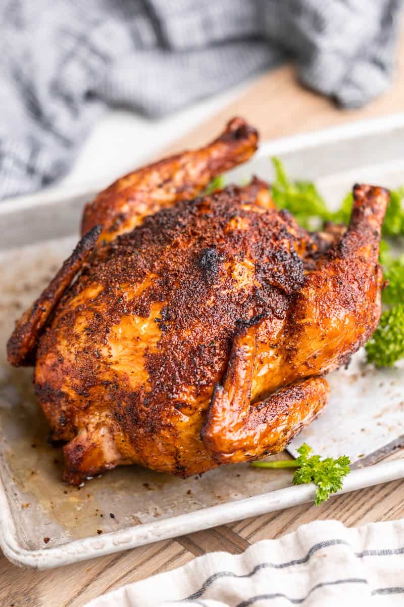 A smoked whole chicken on a baking sheet.