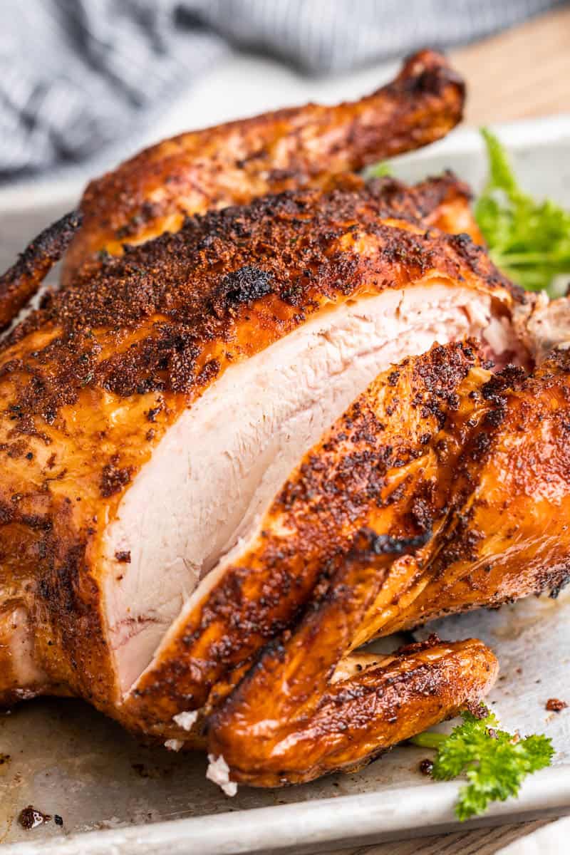 Close up view of a whole smoked chicken.