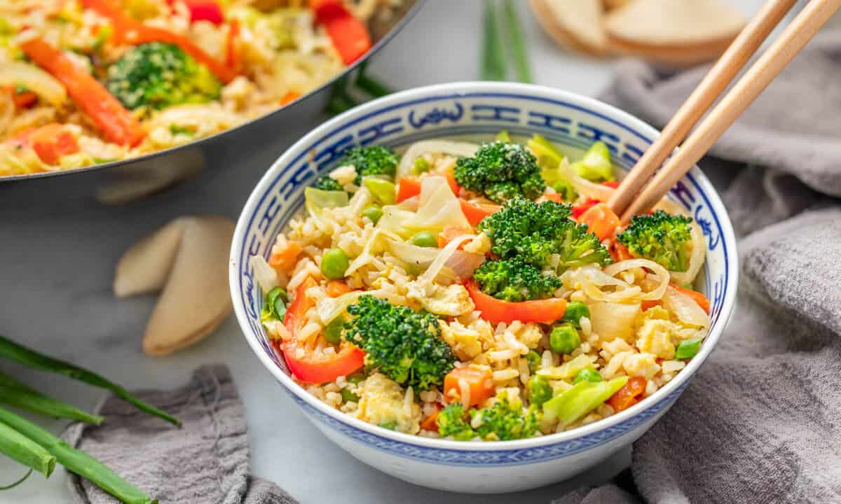 Vegetable fried rice in a bowl with chopsticks.