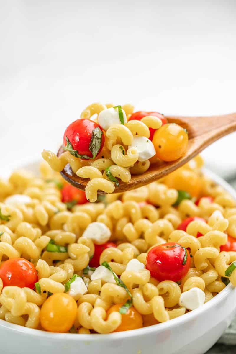 Caprese pasta salad in a wooden spoon.