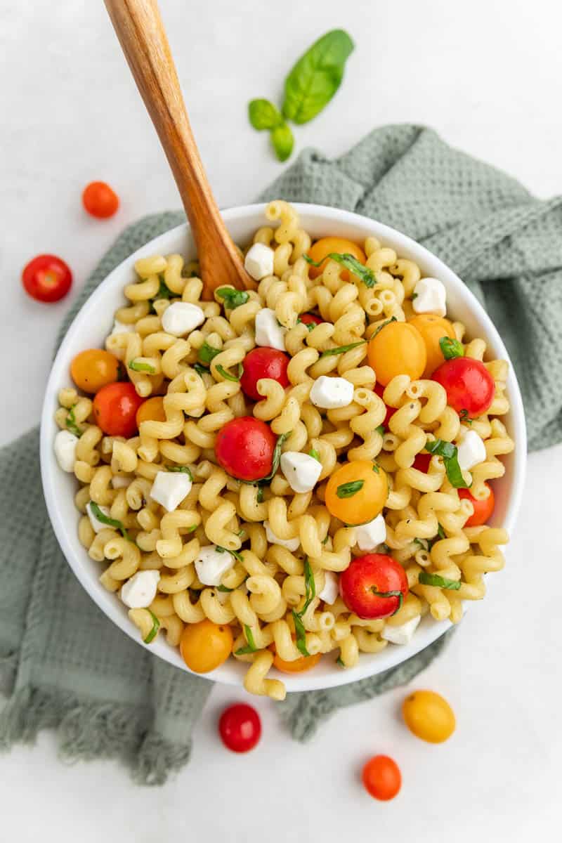 An overhead view of caprese pasta salad in a serving bowl.