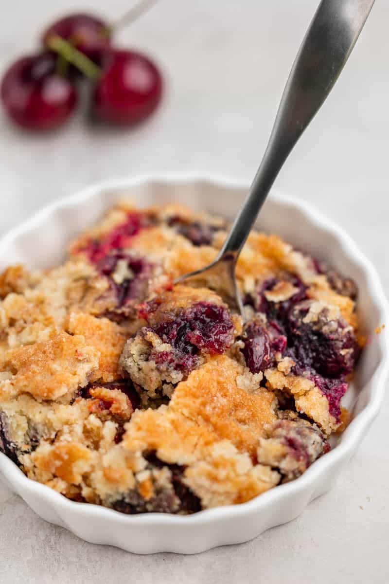 Cherry dump cake in a small white dessert dish.