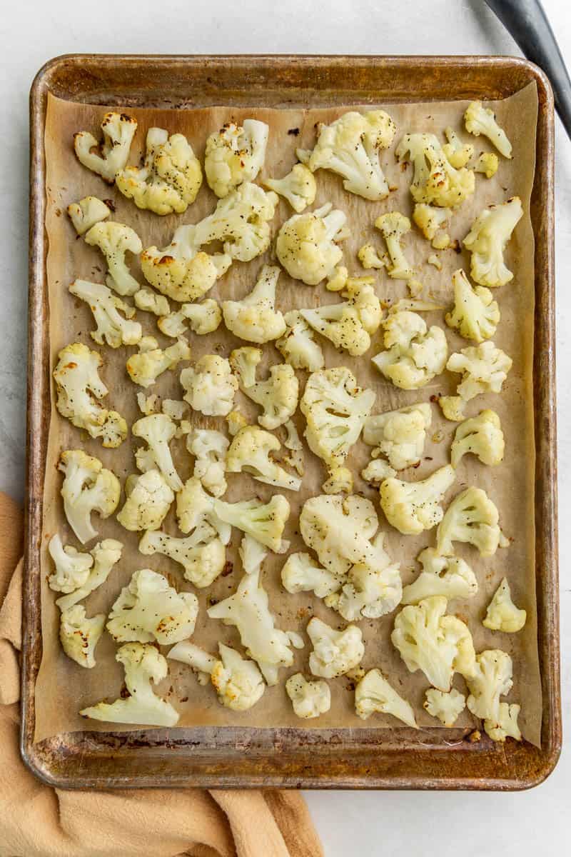 Overhead view of a baking sheet filled with roasted cauliflower.
