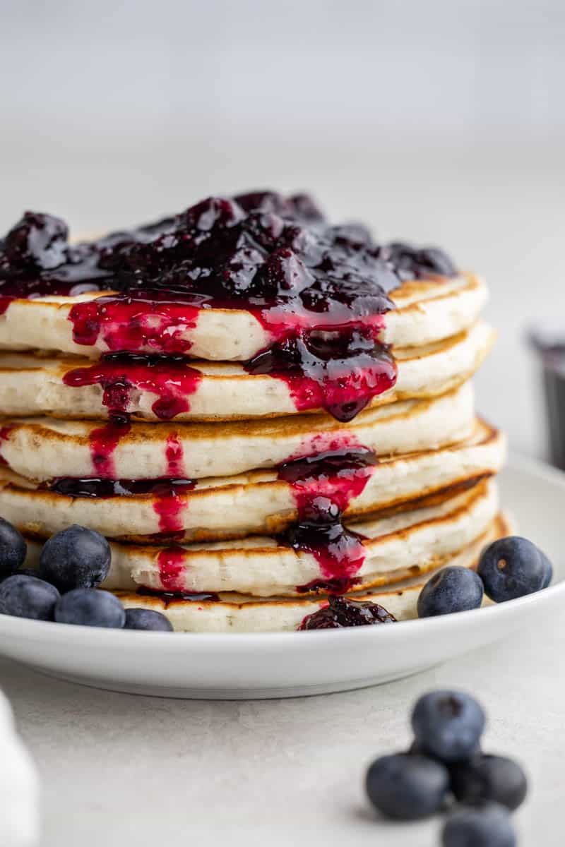 Homemade blueberry syrup on top of pancakes.