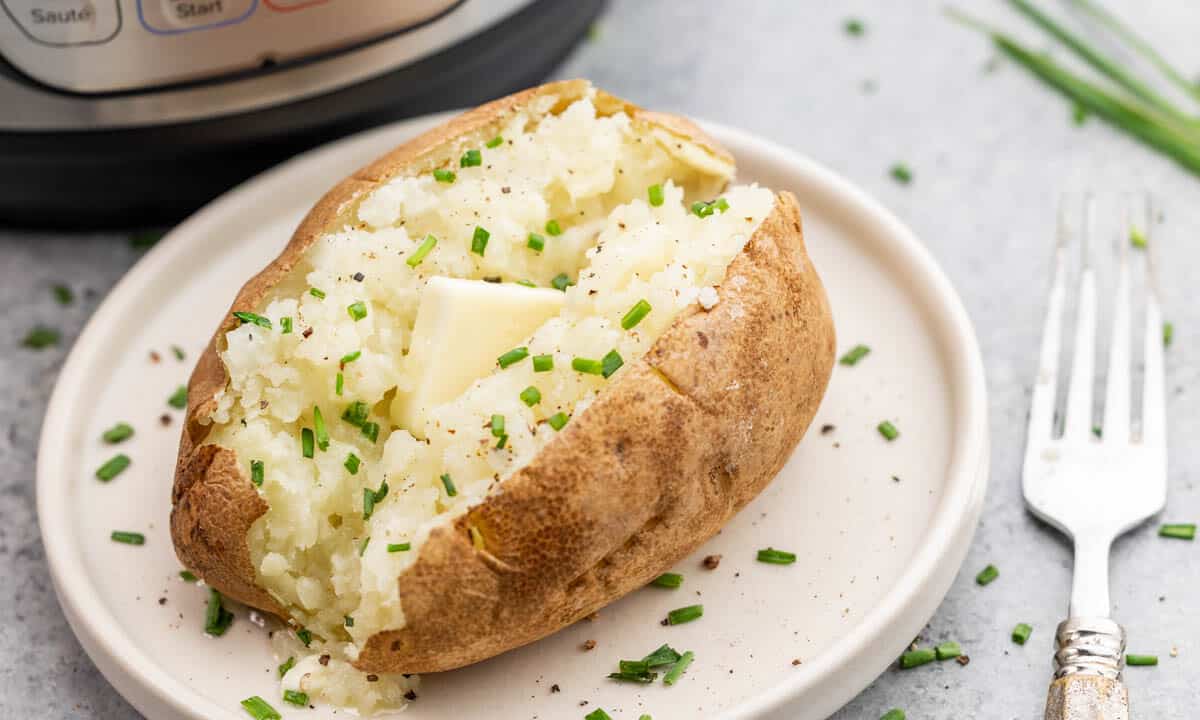 A baked potato on a plate that was baked in an instant pot.