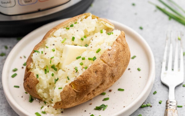 A baked potato on a plate that was baked in an instant pot.