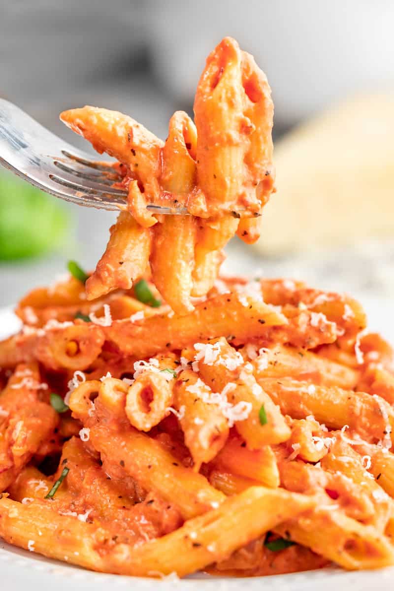 Close up view of penne alla vodka on a fork.