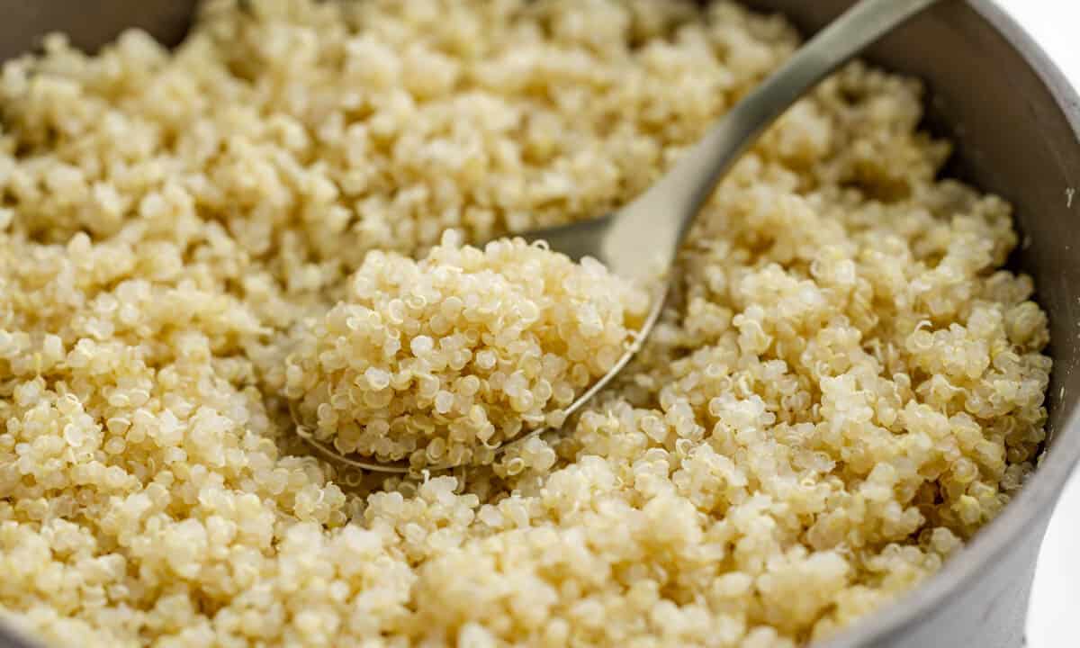 Close up view of quinoa in a saucepan with a spoon.
