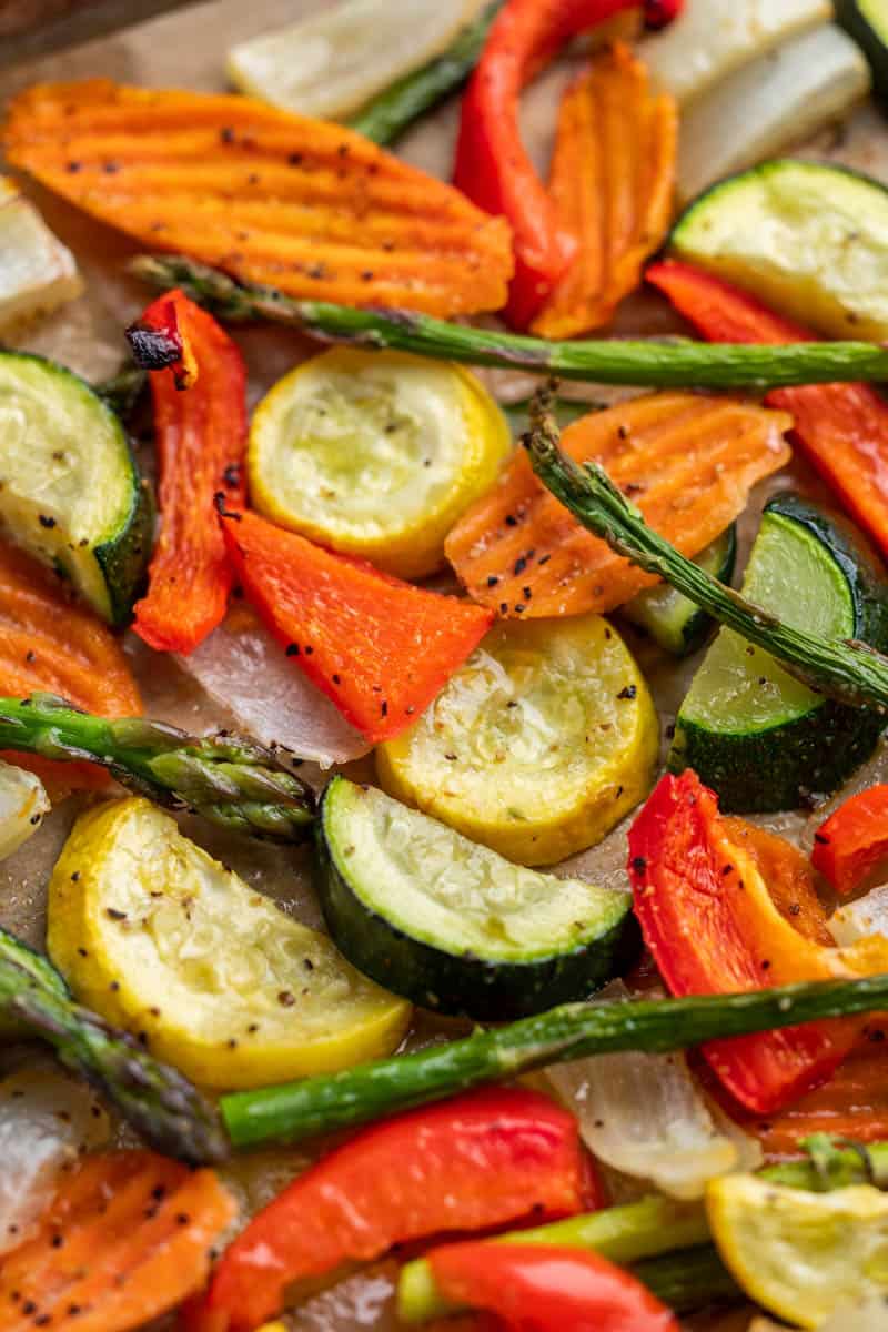 Close up view of spring vegetables on a baking sheet.