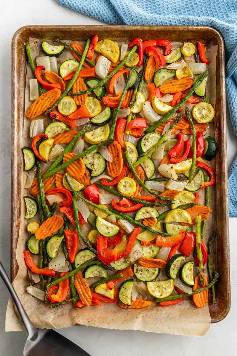 Overhead view of a baking sheet filled with spring vegetables.