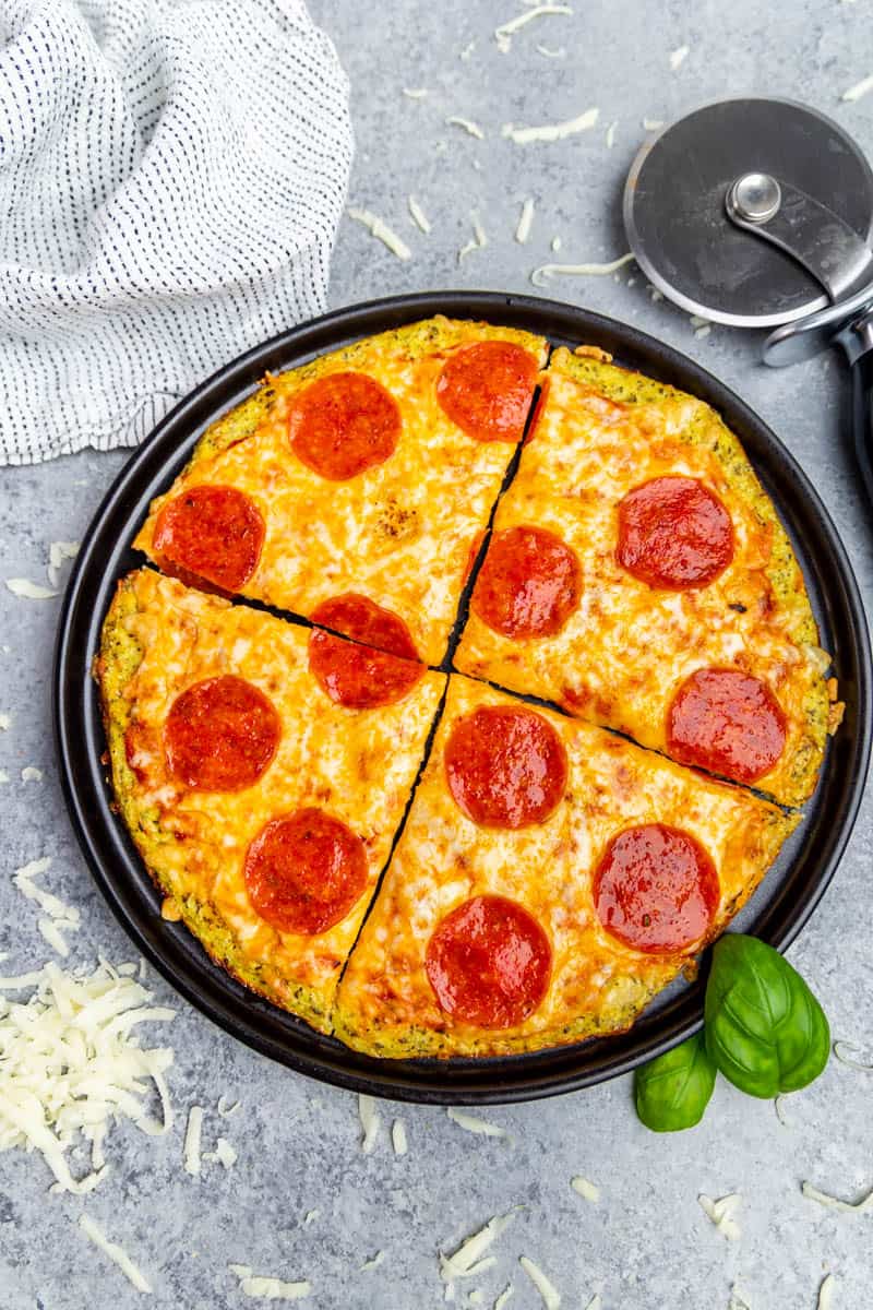 Overhead view of a pepperoni pizza on a pizza pan made with cauliflower crust.