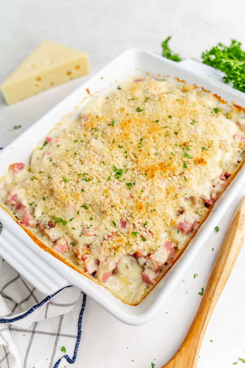 A whole chicken cordon bleu casserole in a white baking dish.