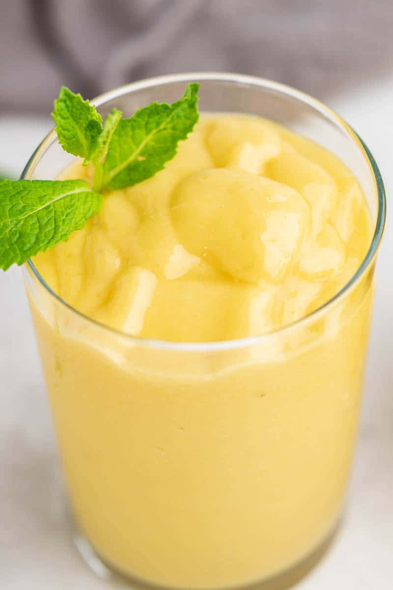 Close up view of a mango smoothie in a glass.
