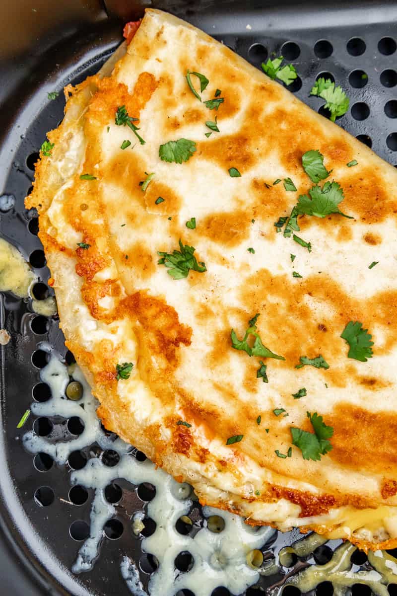 An overhead view of a close up of a quesadilla in the air fryer.