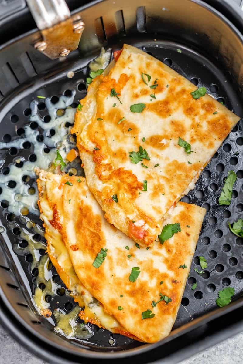 Overhead view of an air fryer basket with a quesadilla.