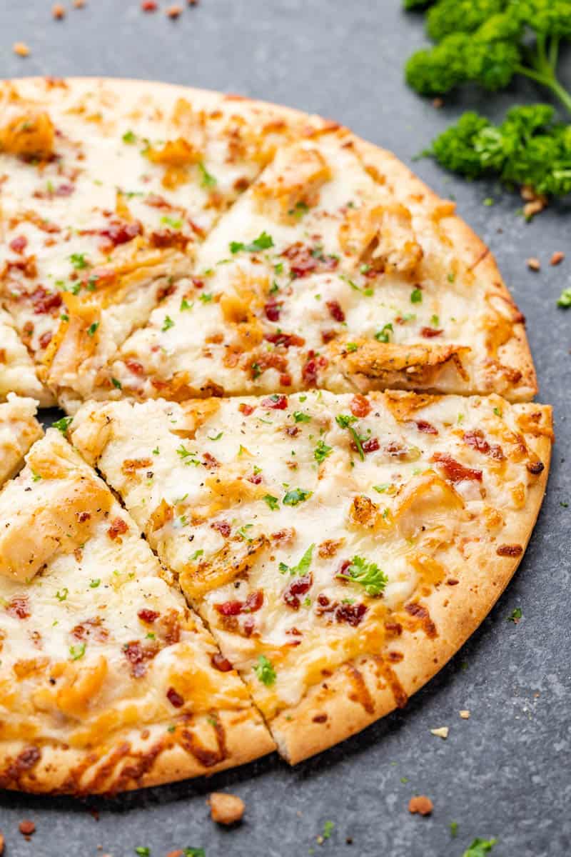Close up view of chicken alfredo pizza.