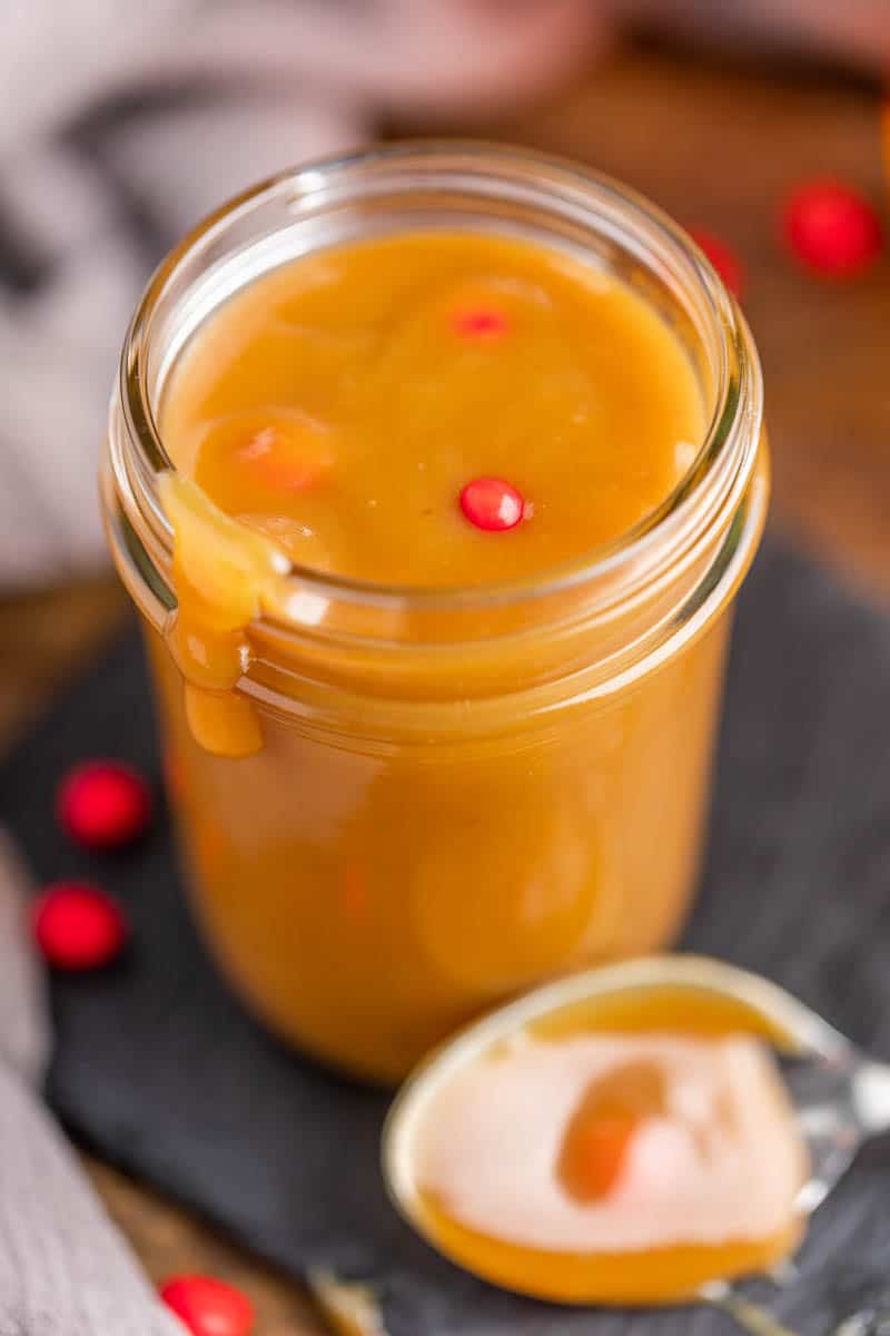 Close up view of fireball cinnamon caramel sauce in a glass jar.