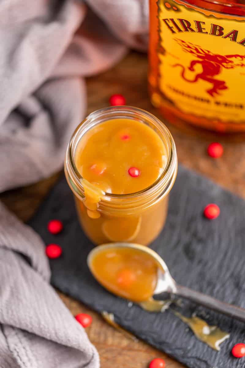 Overhead view looking into a small glass jar filled with homemade fireball cinnamon caramel sauce.