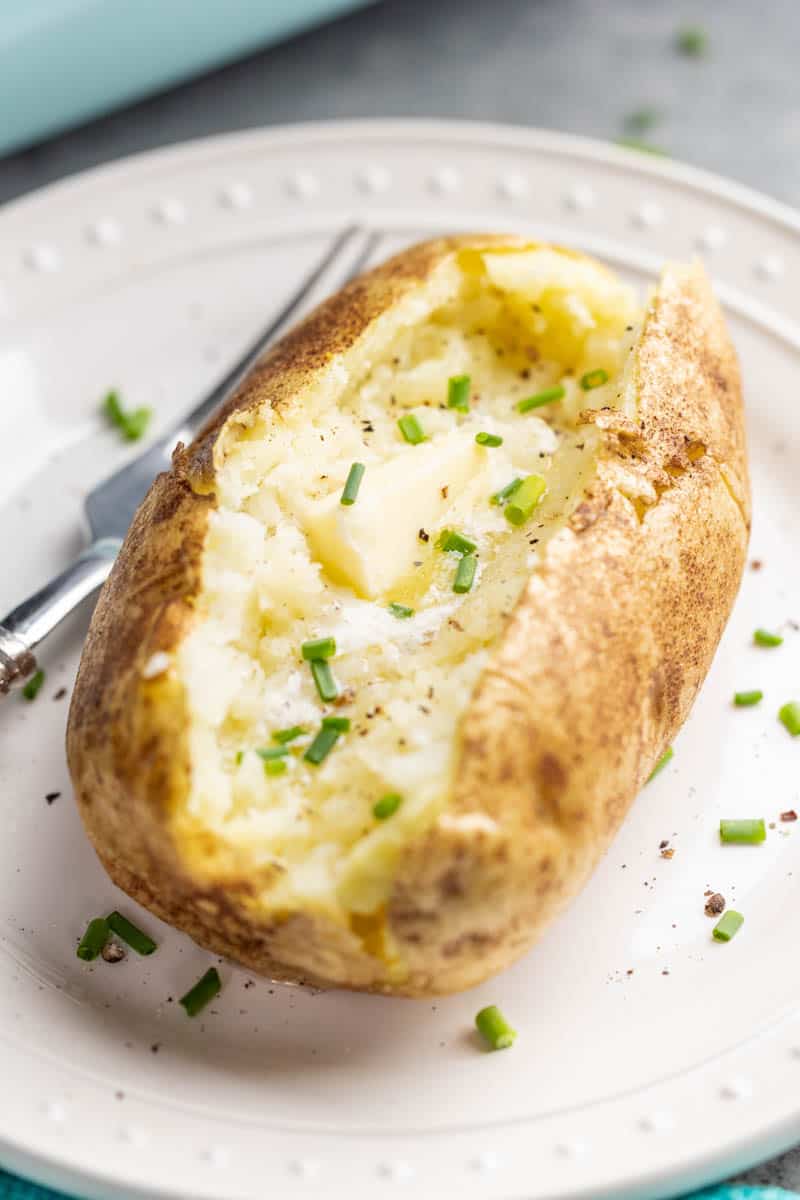 Close up view of a baked potato cut down the center.