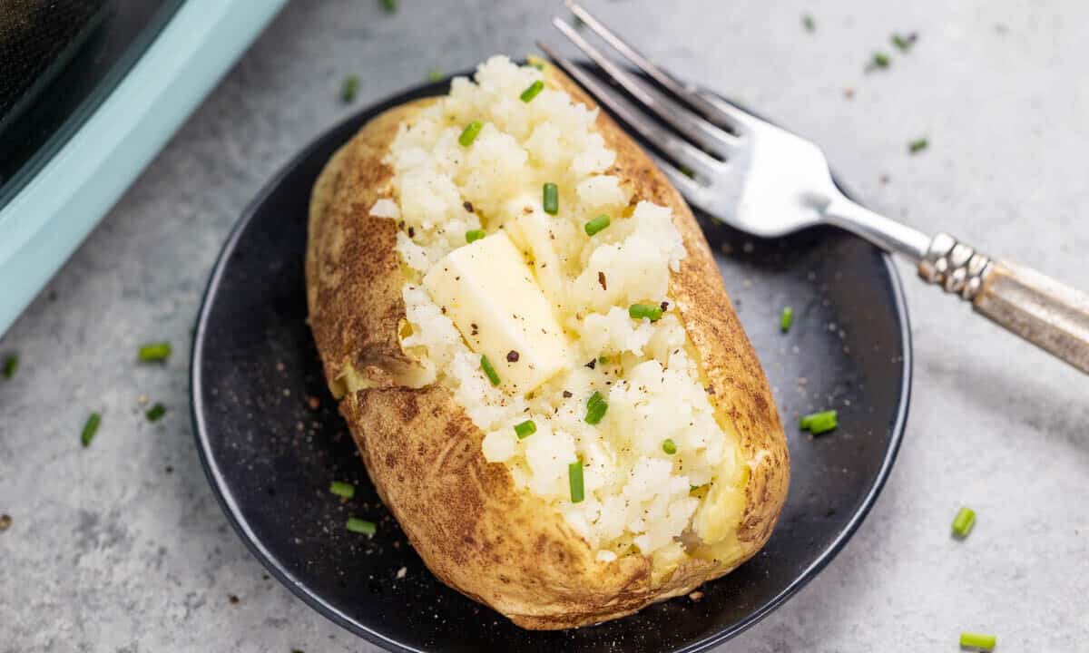 A baked potato with a pat of butter inside.