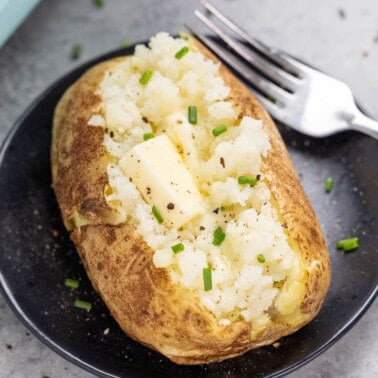 A baked potato with a pat of butter inside.